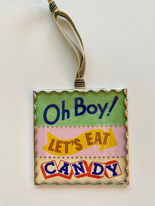 Decorative sign with 'Oh Boy! Let's Eat Candy' text on a light background